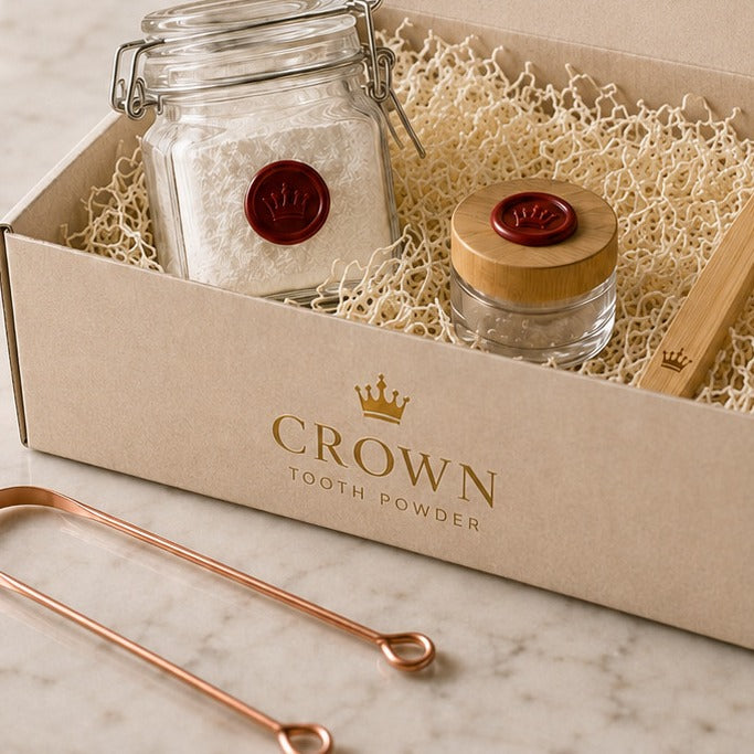 Your first Crown box open on a marble counter with the wax sealed jar, the glass travel jar, and the copper tongue scraper